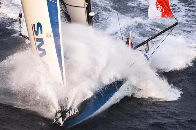 An IMOCA60 drives through a wave with obvious consequences for an untethered sailor on the foredeck. © Vendee Globe http://www.vendeeglobe.org