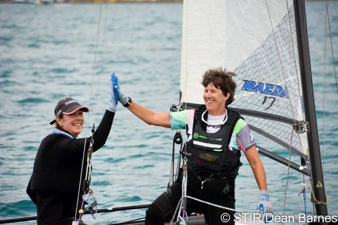 The team aboard Nacra 17, Flight Risk, with Teri McKenna (right) as crew give a high five after racing. © Dean Barnes