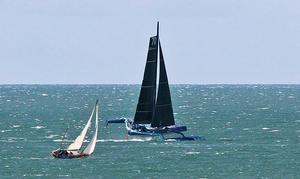 Off to Fastnet - The MOD70 Team Concise goes roaring past a boat returning to Poole after Cowes Week photo copyright Mark Jardine taken at  and featuring the  class