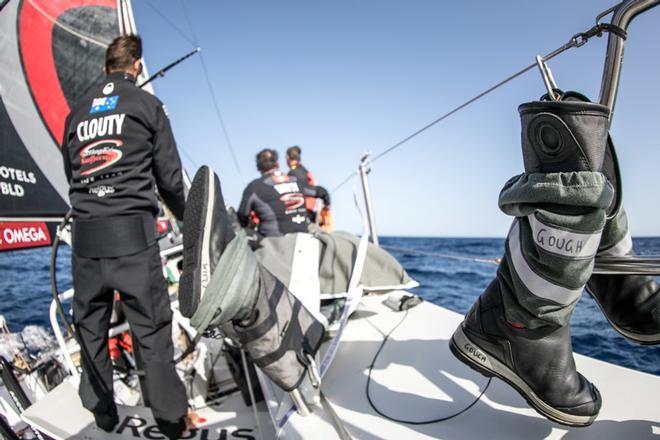 Leg 1, Day 6 – Alicante to Lisbon, afternoon onboard Sun Hung Kai/Scallywag. Australian Tom Clout helms as his teammates' boots dry in the sea breeze – Volvo Ocean Race ©  Jeremie Lecaudey / Volvo Ocean Race