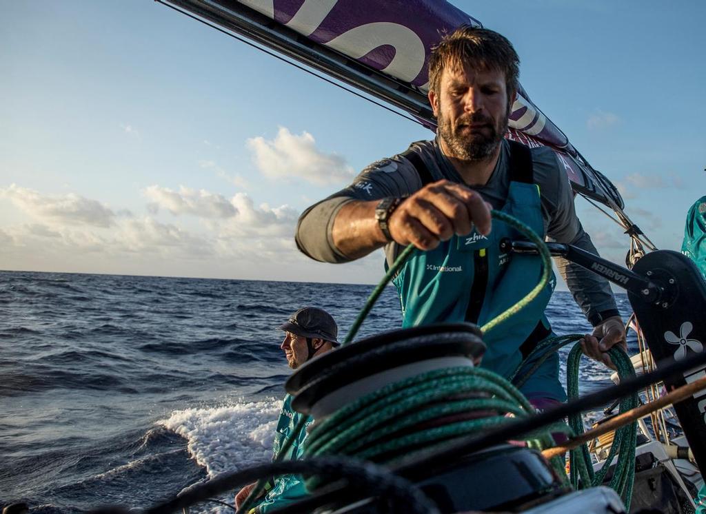 Leg 02, Lisbon to Cape Town, day 10, on board AkzoNobel. Simeon Tienpont tidying a halyard away. Luke Molloy in background soaking up the last rays of the day. Volvo Ocean Race. 14 November, 2017. ©  James Blake / Volvo Ocean Race