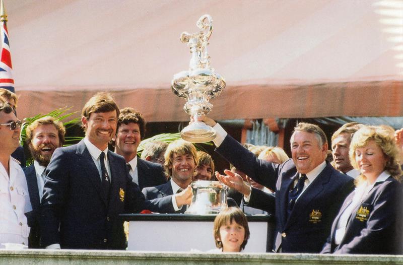 John Bertrand, helmsman of Australia II (left) whole syndicate head, Alan Bond holds the America's Cup aloft for all spectators and press members to see, from the lawn of the Vanderbilt's Marble House - photo © Paul A. Darling