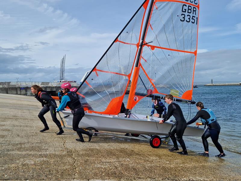 UK Nacra 15 sailors helping the 29er fleet ashore on windy Wednesday during the 2024 RYA Youth Nationals photo copyright Su Smith taken at Weymouth & Portland Sailing Academy and featuring the 29er class