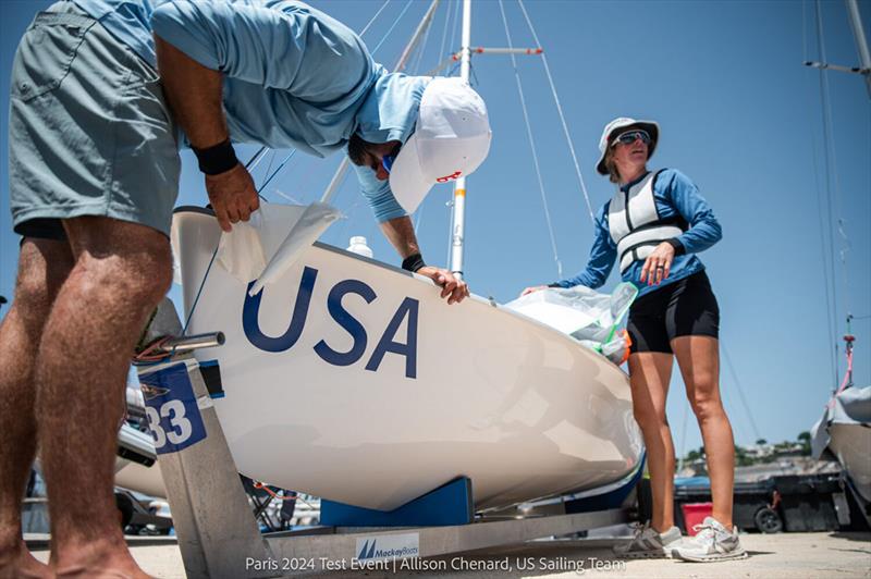Stu McNay finishes applying USA bow stickers to his and Lara Dallman-Weiss's 470 - Paris 2024 Test Event - photo © Allison Chenard