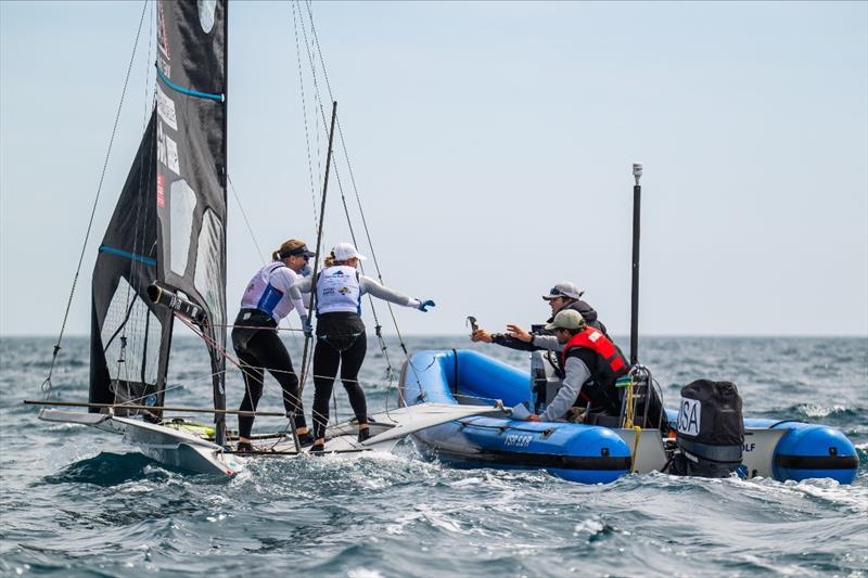 49er FX athletes Stephanie Roble and Maggie Shea receive input from USST 49erFX coach Evan Aras and skiff specialist Dave Evans between races on day five of the Trofeo Princesa Sofía - photo © US Sailing Team