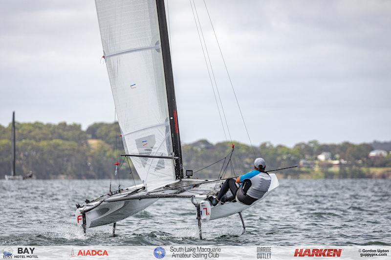 Australian A-Cat Nationals on Lake Macquarie Day 2 - Matt Holman gets airborne in 13 knots of boatspeed photo copyright Gordon Upton / www.guppypix.com taken at South Lake Macquarie Amateur Sailing Club and featuring the A Class Catamaran class