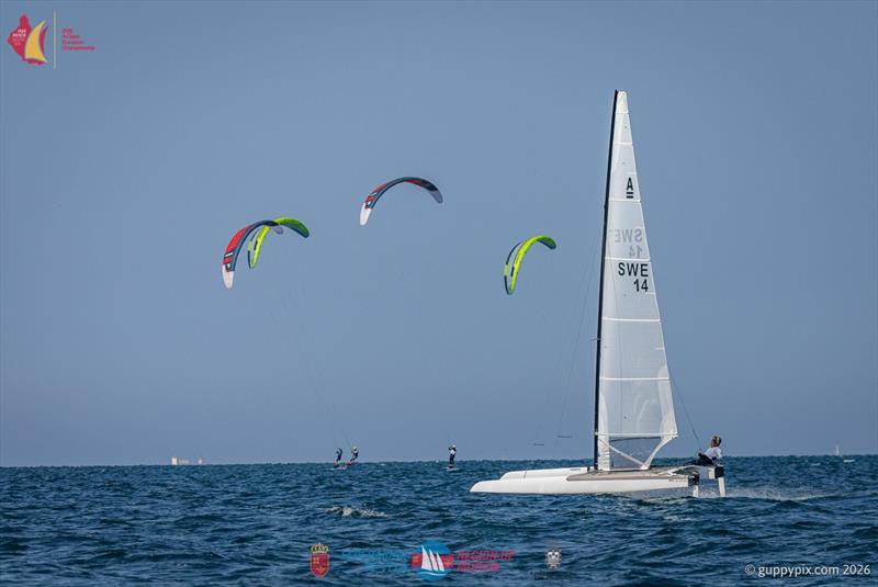 A Class Catamaran Europeans Day 1 - A-Cat 'Newbie', the Nacra 17 sailor Emil Jaradd SWE seems to be plagued by the ESP Kiteboard team on the Mar Menor while sailing home to the beach photo copyright Gordon Upton / www.guppypix.com taken at  and featuring the A Class Catamaran class