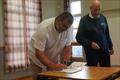 Club Commodore, Scott McColm signing the Dumfries and Galloway Council Coastal Benefit Fund Grant Acceptance Form, accompanied by Ian Purkis, Project Lead during the Challenger Scottish Championship