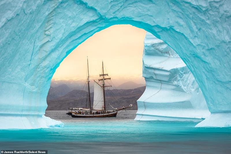A photographer captured the moment a fishing boat was beautifully framed by a gigantic archway of ice off the coast of Greenland  photo copyright James Rushforth taken at  and featuring the Cruising Yacht class
