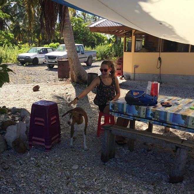 Camille of SV Anila doing school work ashore at Pakakota while Dad fixed the broken water maker. Bonus was petting the owner's dog photo copyright Henk and Lisa Benckhuysen taken at  and featuring the Cruising Yacht class