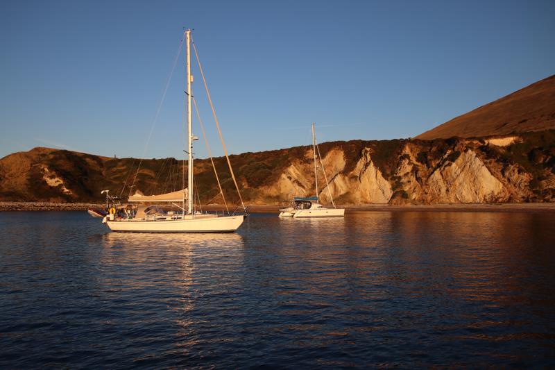 Coruisk and a catamaran in the dawn light in Warbarrow Bay photo copyright Reg Barker taken at Ocean Cruising Club and featuring the Cruising Yacht class