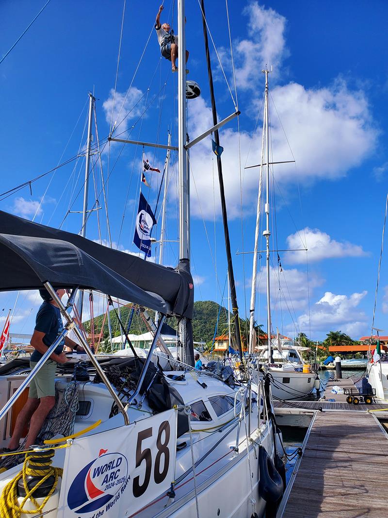 Skipper John Ramsden from Sofa So Good gets hoisted up the mast to do a rigging check before departure - World ARC 2024-25 photo copyright World ARC taken at  and featuring the Cruising Yacht class