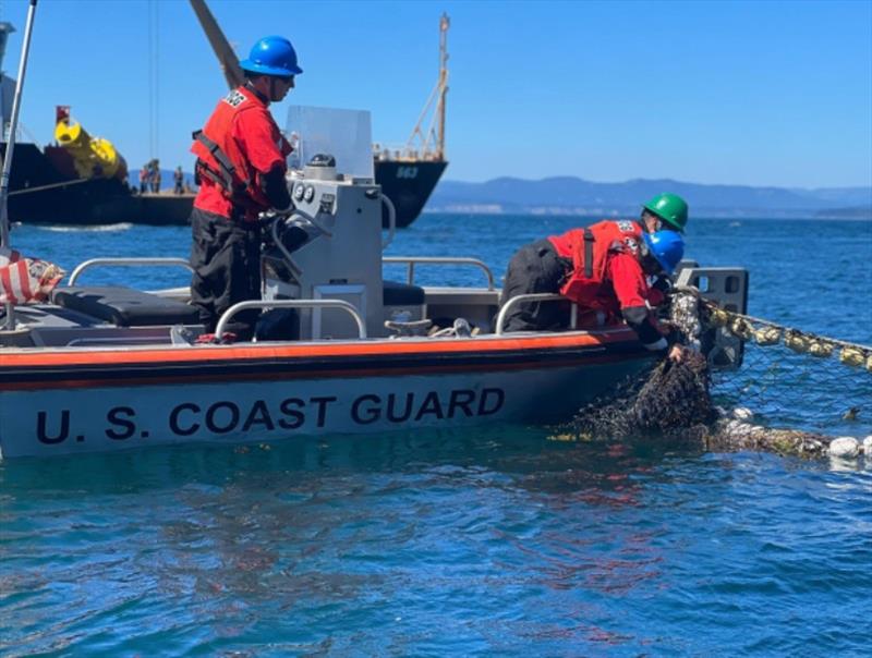 A U.S. Coast Guard team removing the floating netting on August 24, 2022 photo copyright U.S. Coast Guard taken at  and featuring the Environment class