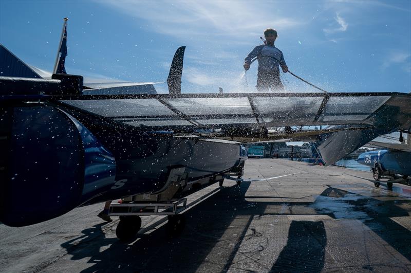 A crew member washes the USA SailGP Team F50 catamaran in the Technical Base after a practice session ahead of the Great Britain Sail Grand Prix | Plymouth in Plymouth, England. 29th July 2022 - photo © Jon Super/SailGP