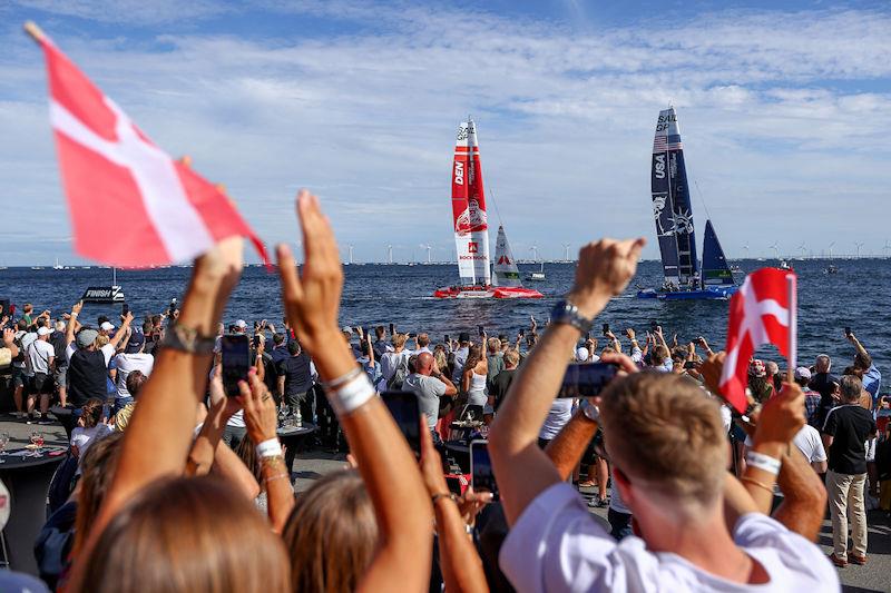 Fans in the Race Village cheer and wave flags as USA SailGP Team and Denmark SailGP Team presented by ROCKWOOL cross the finish line on Race Day 2 of the ROCKWOOL Denmark Sail Grand Prix in Copenhagen, Denmark photo copyright Chloe Knott for SailGP taken at  and featuring the F50 class