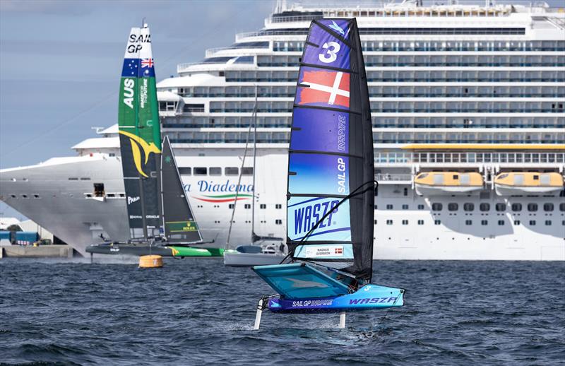 The Australia SailGP Team F50 catamaran and the Costa Diadema cruise ship are seen in the background as a young sailor takes part in the Inspire Racing x WASZP program on Race Day 2 of the ROCKWOOL Denmark Sail Grand Prix in Copenhagen, Denmark. - photo © Felix Diemer for SailGP
