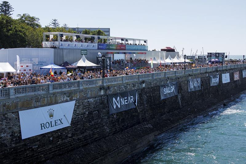 Sponsor signs hang on on the wall near the Fan Village as spectators watch the action on Race Day 1 of the Spain Sail Grand Prix in Cadiz, Andalusia, Spain. 24th September photo copyright David Gray for SailGP taken at  and featuring the F50 class