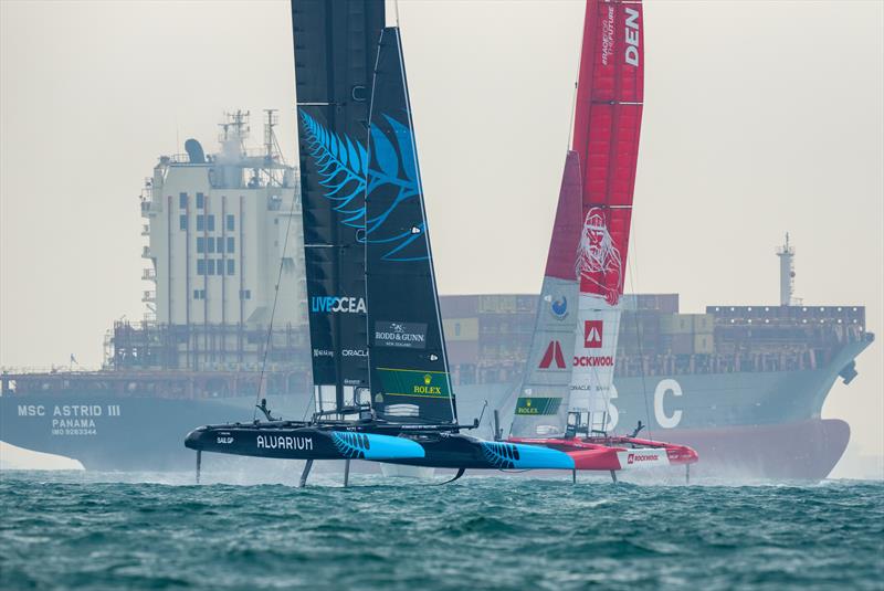 New Zealand SailGP Team  and Denmark SailGP Team battle in thew foreground of a cargo ship on Race Day 2 of the Singapore Sail Grand Prix  photo copyright Eloi Stichelbaut/SailGP. taken at Singapore Yacht Club and featuring the F50 class