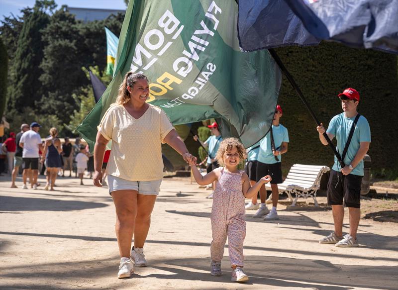 Spectators walking past team flags as they make their way to the Race Stadium on Race Day 1 of the DP World Spain Sail Grand Prix - photo © Gary Oakley for SailGP