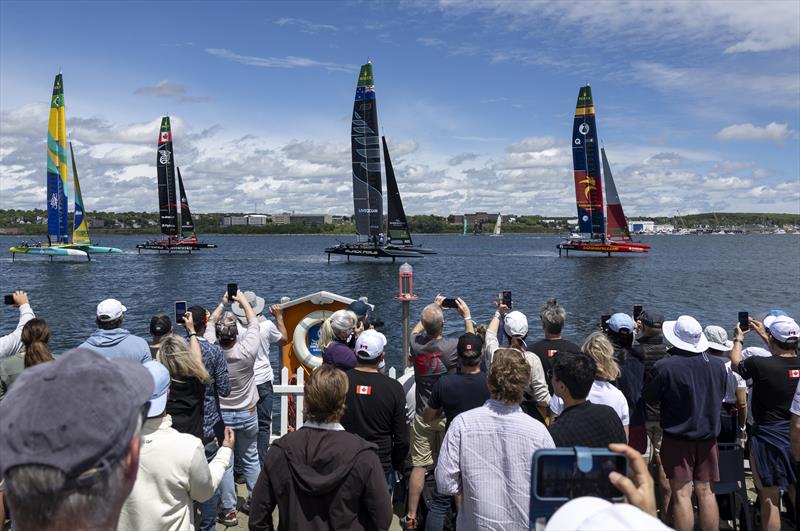 Spectators in the Vela Beach Club watch as the fleet led by Los Gallos SailGP Team ahead of Black Foils SailGP Team sail past on Race Day 2 of the Canada Sail Grand Prix in Halifax, Canada photo copyright Katelyn Mulcahy for SailGP taken at  and featuring the F50 class