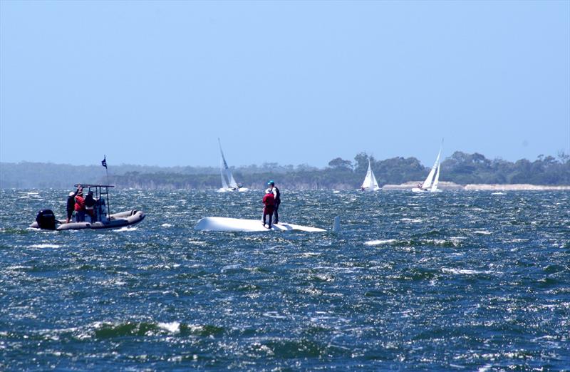 A RIB crew checks the welfare of Michael Wood and Wayne Smith on Whoosh, upturned after achieving the leeward mark and right in the way of the Flying Dutchman fleet on their way to the finish line - photo © Jeanette Severs