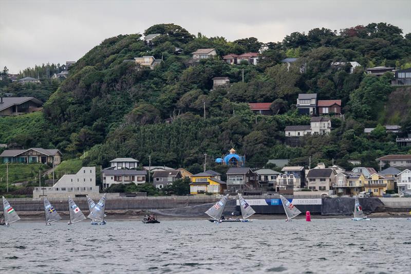 Tokyo2020 - Day 1 of the Finn class with the top mark dropped in front of a high bluff and close to shore - with a light offshore breeze. Three of the top five overall scored their discard in the opening race. - photo © Richard Gladwell - Sail-World.com/nz