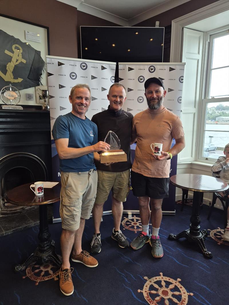 Ewen Barry and Sandy Remmington (15183) presented with the trophy by Brian Jones (Munster Rep) during the Fireball Munster Championship 2026 at Monkstown Bay - photo © Shane O'Connell