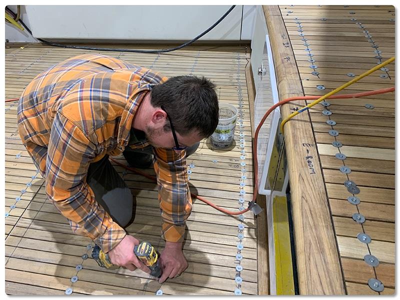 Jason Bantum (of Michael Bantum, Inc., a Viking vendor) has finished securing the teak in the cockpit of hull No. 64 - photo © Viking Yachts