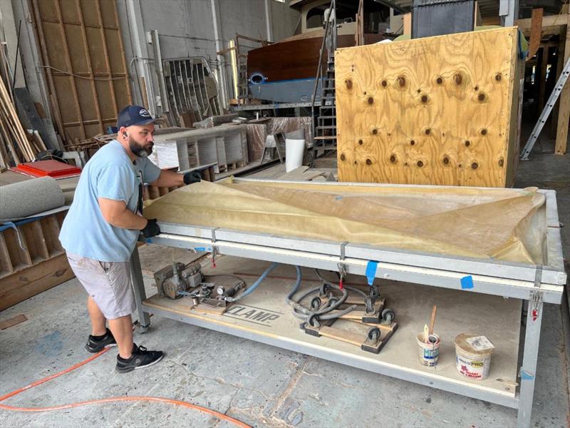 Hull #8 - Chris F veneering on the vacuum table - photo © Michael Rybovich & Sons