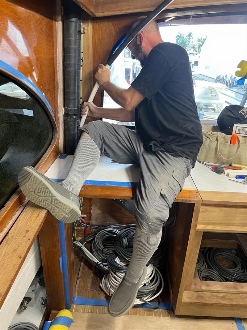 Hull #8 - Jamie installing condensation drains - photo © Michael Rybovich & Sons