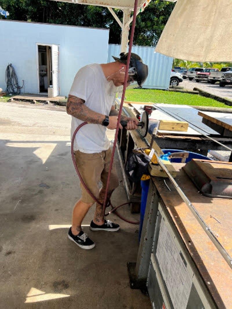 Hull #8 - Jason polishing guard metal - photo © Michael Rybovich & Sons