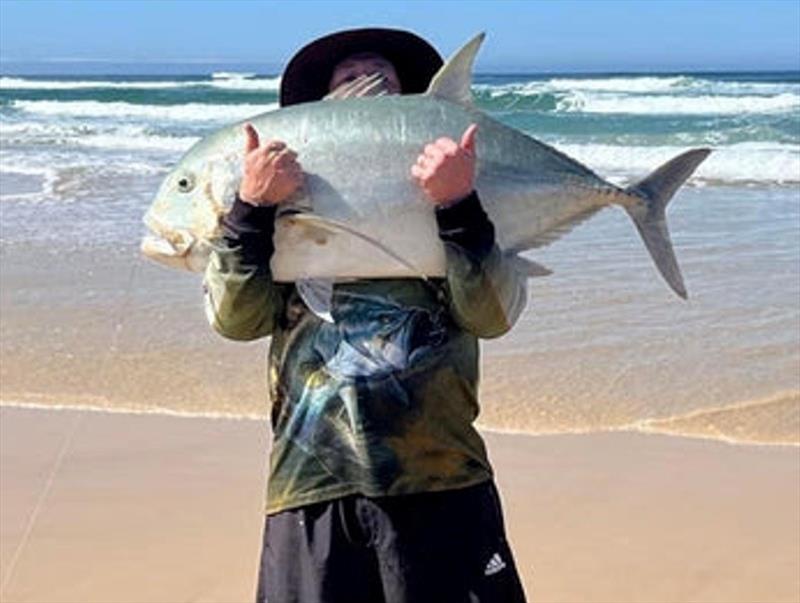 Dale Williams hiding behind a monster GT he caught from the surf. Few people get to experience such a thrill. Ripper fish mate photo copyright Fisho's Tackle World taken at  and featuring the Fishing boat class