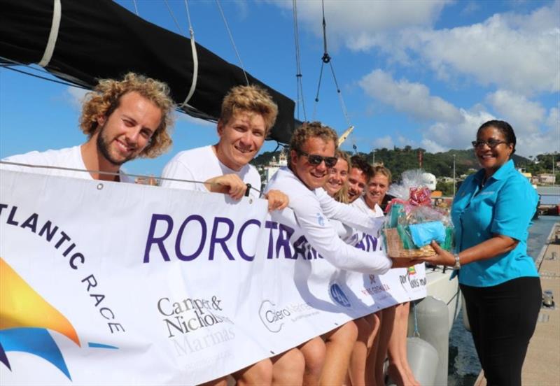 Andy Lis and the crew of Pata Negra receive a basket of Grenadian goods from Nikoyan Roberts, Grenada Tourism Authority after completing the 2019 RORC Transatlantic Race photo copyright RORC / Louay Habib taken at Royal Ocean Racing Club and featuring the IRC class