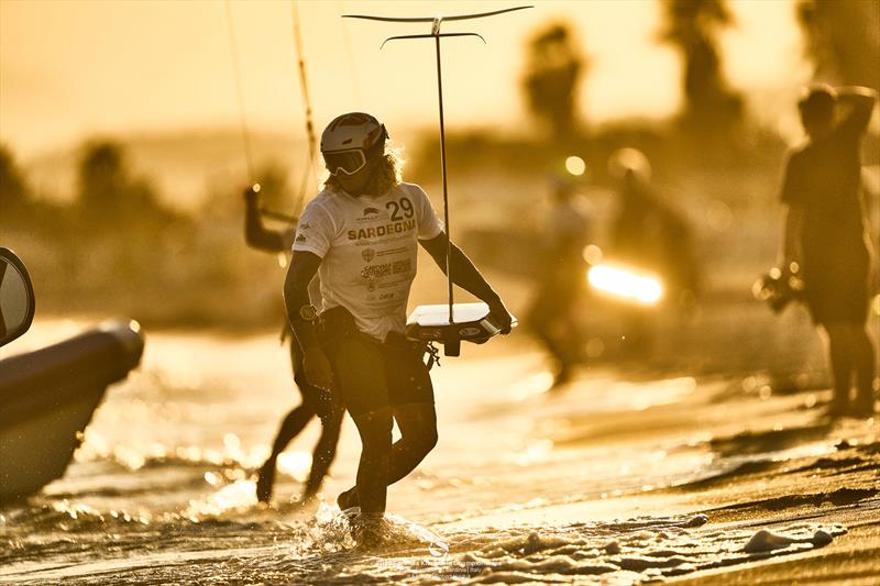 Marcel Stepniewski steps ashore in the vibrant sunset of Poetto Beach - 2025 Formula Kite World Championships - photo © IKA Media / Robert Hajduk