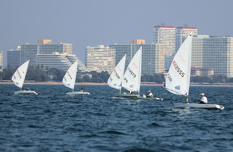 ILCA 6 fleet downwind with the Pattaya skyline in the background on day 1 of the Open Masters Championship 2026 photo copyright James Young taken at Royal Varuna Yacht Club and featuring the ILCA 6 class