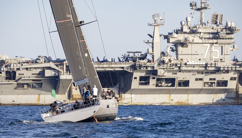 Gregor Stimpfl's Hägar V with the 332m long USS Harry S Truman. - 2022 IMA Maxi European Championship photo copyright ROLEX / Studio Borlenghi taken at Circolo del Remo e della Vela Italia and featuring the Maxi class