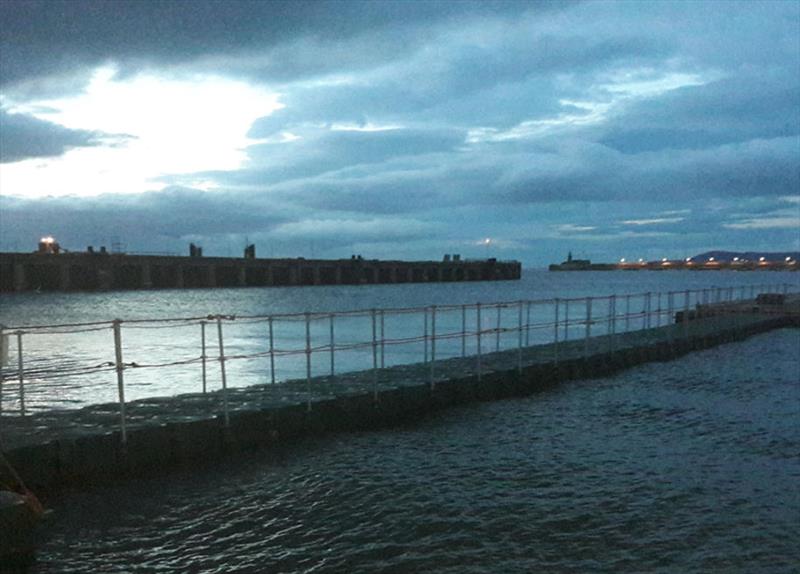 Night-time photo of the bridge to the pontoons in Dun Laoghaire Harbour photo copyright Cormac Bradley taken at 