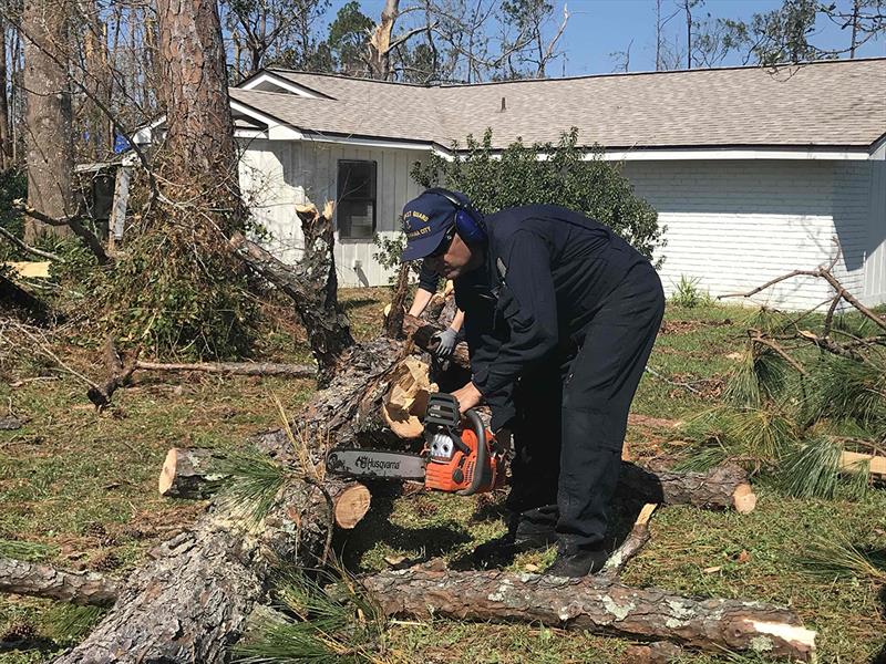 A Coast Guard member from Station Panama City helps a local resident clear storm debris from his property, Oct. 18, 2018 photo copyright Petty Officer 3rd Class Nathan Cox taken at 