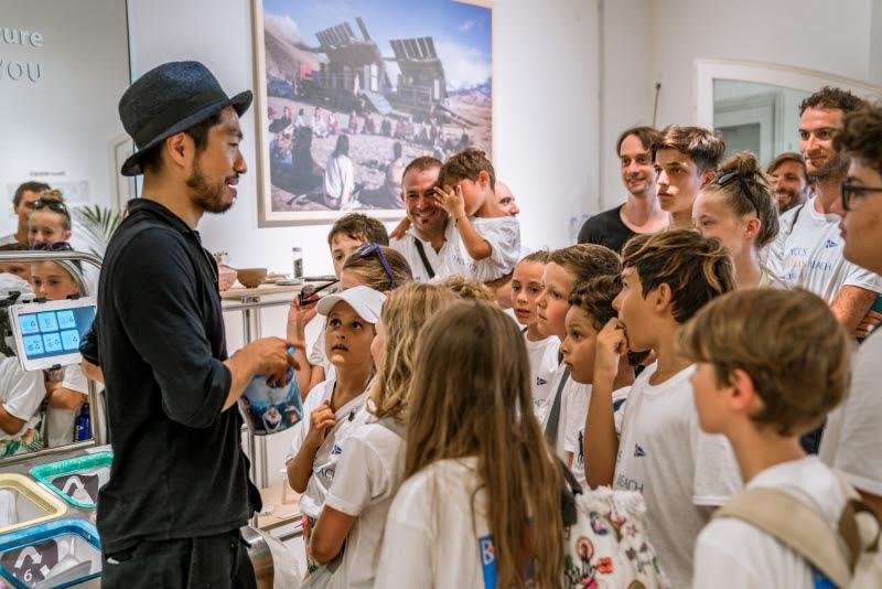 Arthur Huang, MINIWIZ CEO explains to the Sailing School kids how the MINIWIZ recycling lab works at the pop-up store at Promenade du Port. - photo © YCCS / Marcello Chiodino