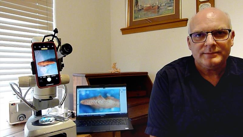 Chris Gburski with his cellphone and dissecting microscope set up photo copyright NOAA Fisheries taken at 