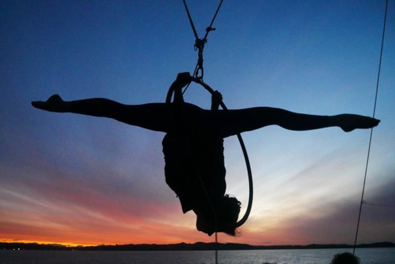 Not your average boat in the sunset silhouette: aerialist Rumah hard at work in the rigging. - photo © Jorge Rodriguez Roda