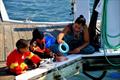 Two-year-old Jahzeel Ashby and 5-year-old brother, Lester Ashby, fish with mother Rosa Feliz © Dean Barnes