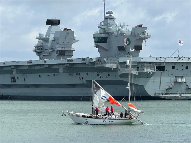 Galiana WithSecure FI (06) passing HMS Queen Elizabeth after dismasting in the Fastnet Race. Down but not out photo copyright Rob Havill / OGR2023 taken at  and featuring the Ocean Globe Race class