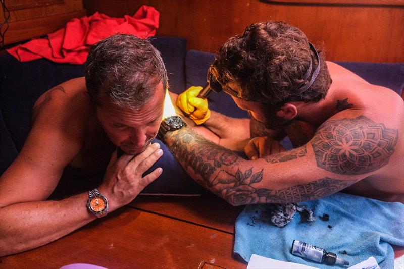 Always time for tattoos at sea! Sam working his magic on a very brave Dane - McIntyre Ocean Globe Race - photo © OGR2023 / Godspeed / Skeleton Crew / Emma Walker