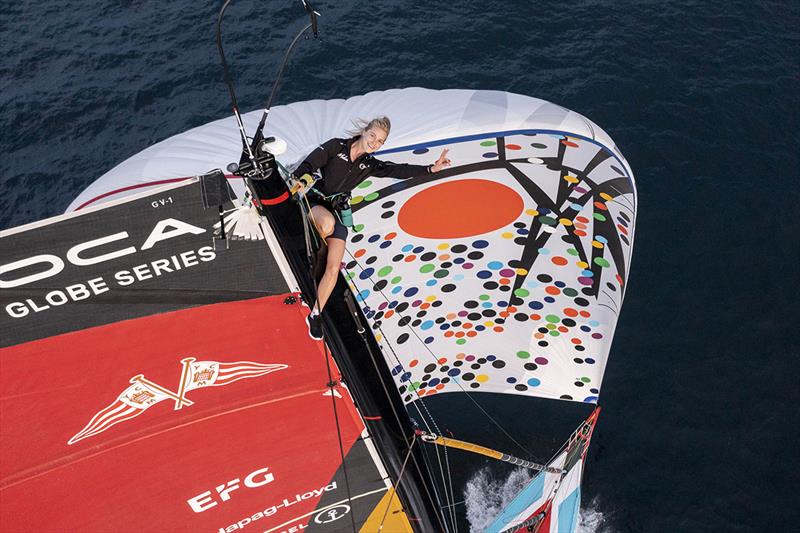 Team Malizia's co-skipper Rosalin Kuiper on the top of the Malizia - Seaexplorer with the spinnaker sail designed by Sarah Morris in the background - photo © Yann Riou