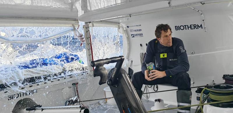 The Ocean Race Leg 1 onboard Biotherm: Paul Meilhat during lunch with the waves hitting photo copyright Minghao Zhangh / Biotherm taken at  and featuring the IMOCA class