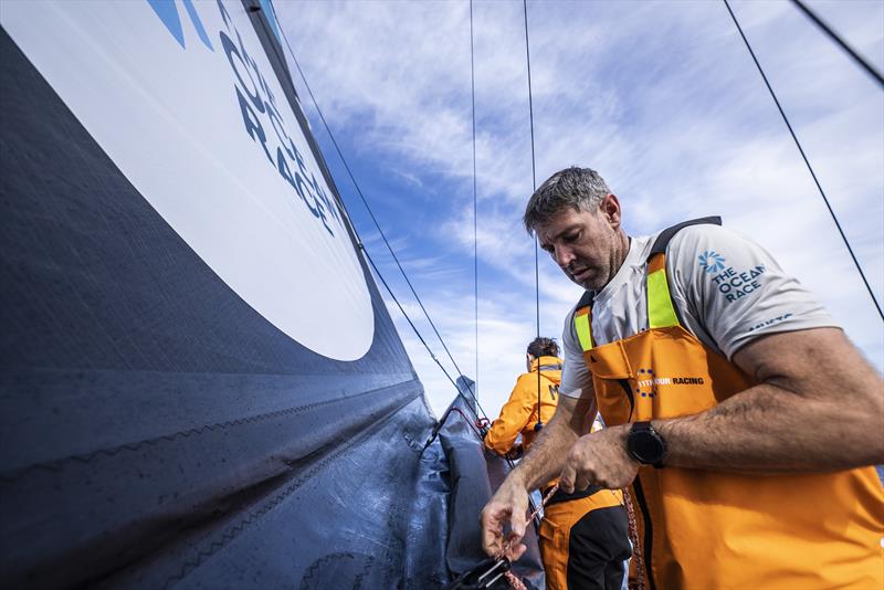 The Ocean Race 2022-23 Leg 3 onboard 11th Hour Racing Team - Simon Fisher and Justine Mettraux add reef ties to the mainsail to prevent water buildup and wind damage - photo © Amory Ross / 11th Hour Racing / The Ocean Race