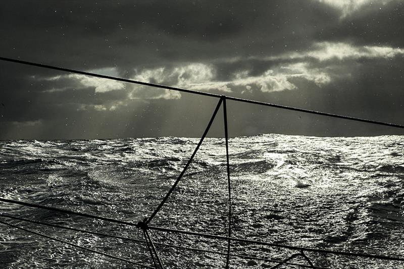 The Ocean Race 2022-23 Leg 3 Day 7 onboard 11th Hour Racing Team with dramatic lighting to end the day as the low sun pokes through a thick layer of cloud, illuminating a rough sea - photo © Amory Ross / 11th Hour Racing / The Ocean Race