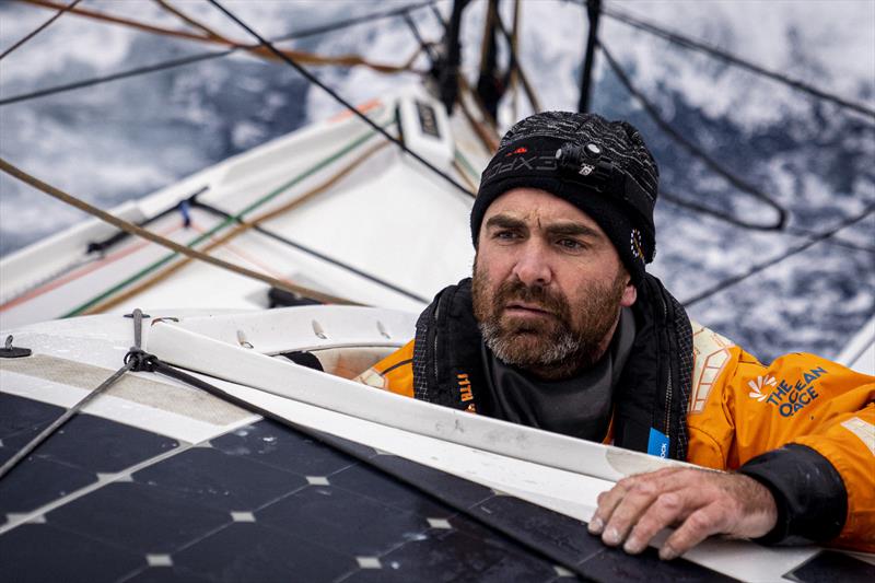 The Ocean Race 2022-23 Leg 3 onboard 11th Hour Racing Team. Charlie Enright sticks his head out of the cockpit to communicate with the group on deck photo copyright Amory Ross / 11th Hour Racing / The Ocean Race taken at  and featuring the IMOCA class