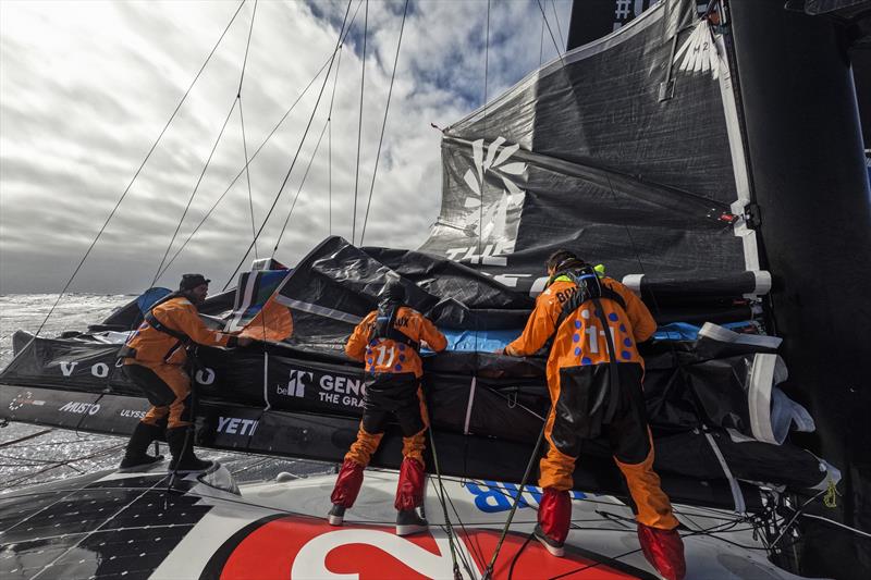 The Ocean Race 2022-23 Leg 3 onboard 11th Hour Racing Team. Charlie Enright, Justine Mettraux and Jack Bouttell work on replacing the broken batten and patching up the mainsail photo copyright Amory Ross / 11th Hour Racing / The Ocean Race taken at  and featuring the IMOCA class